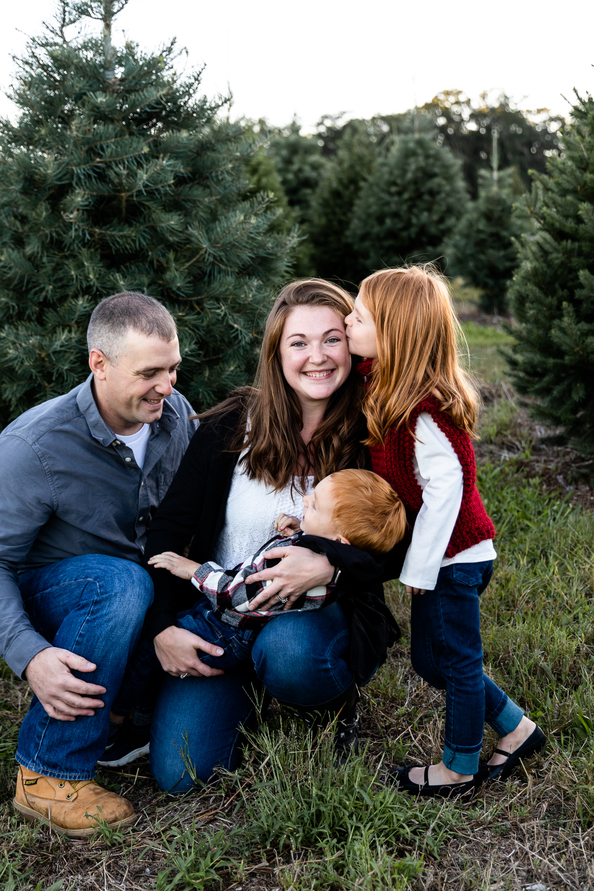 Family snuggling together at Christmas Tree Farm