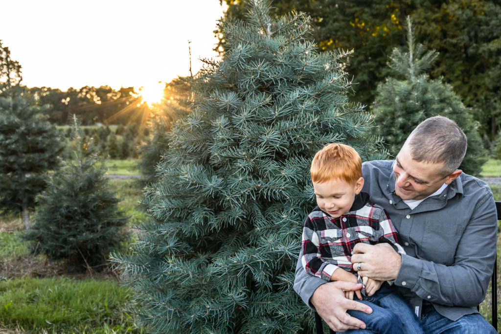 Dad and son snuggling together at Christmas Tree Farm - Connecticut Family Photographer