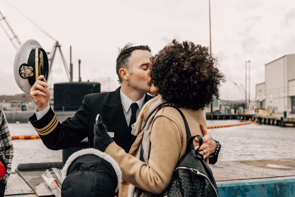 Naval officer kisses his wife after returning from a deployment on USS Minnesota.